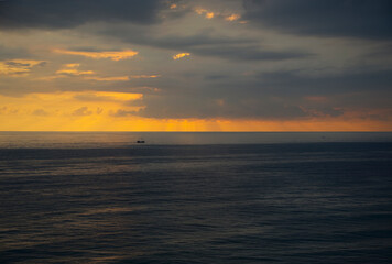 Sailing ship at sea at sunset.