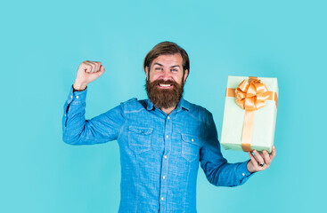 smiling after shopping. businessman hold gift box. gift to colleague at work. surprised man unpacking. the package delivery. human emotion and facial expression. bearded man gift holiday decoration