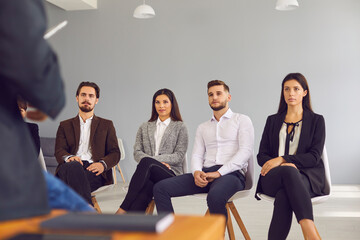 Group of company workers listening to businessman or executive manager making presentation or...