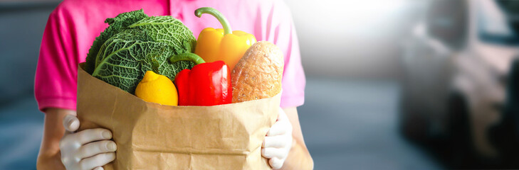 Close up of baguette and fresh vegetables in packet. Express delivery, food delivery, online shopping concept.