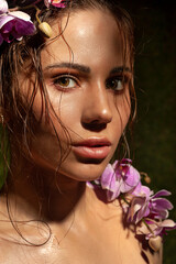Sensual close-up portrait of beautiful girl with orchids