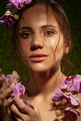 Sensual close-up portrait of beautiful girl with orchids