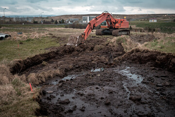 excavator and freshly dug trench