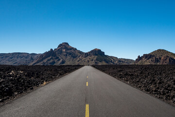 Asphalt road and lava field to volcano Pico de Teide Tenerife