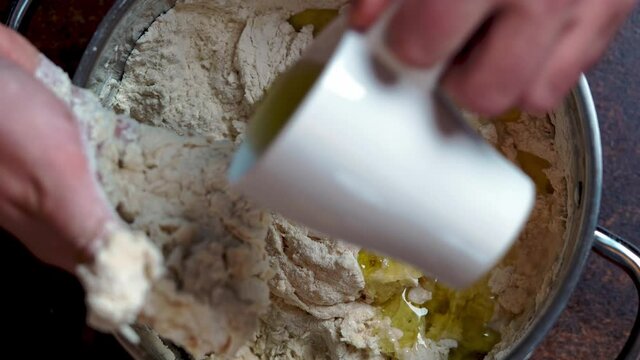 Italian Pizza Dough. the cook adds oliv oil to the flour. DIY homemade dought concept.