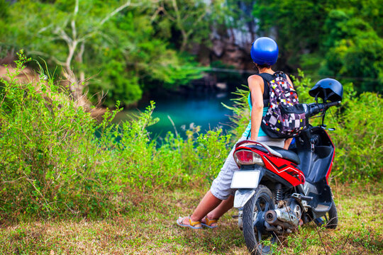 girl biker riding a scooter in the mountains of Vietnam, Woman in blue helmet riding scooter motorbike, Female traveler riding a motorcycle scooter in Vietnam