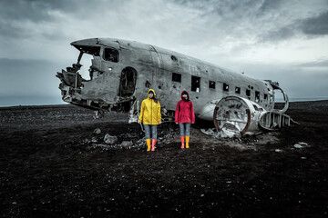 Two girl in yellow and red clothes and Solheimasandur Plane Wreck