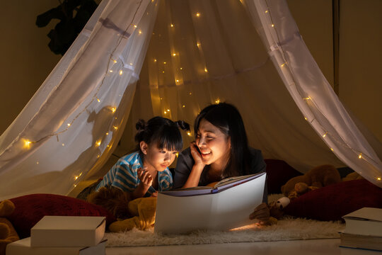 Happy family asian mother and daughter reading a book