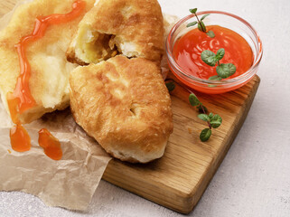 Fresh cutlets stuffed with fried cabbage with ketchup on kitchen board on concrete background