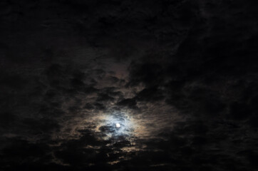 Dramatic night sky with cumulus clouds in moonlight