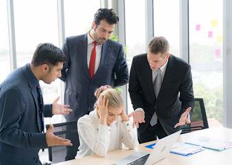 Group of business people are working together and discussing about the project in the meeting room at the office. They are concern about the project timeline. Business woman feel stress