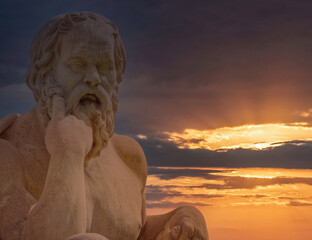 Socrates statue the ancient Greek philosopher illuminated by magic hour dramatic sky, Athens Greece
