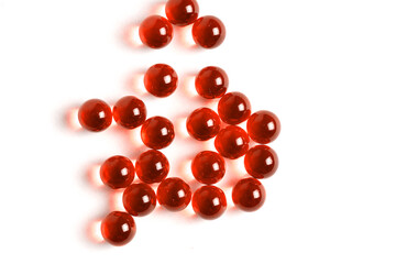 Three Red Pills Capsules with Many in Background Isolated on a White