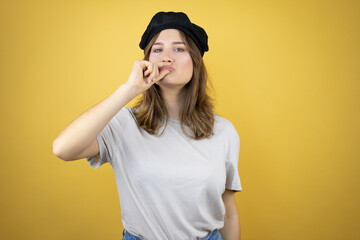 Beautiful young caucasian girl wearing french look with beret over isolated yellow background mouth...