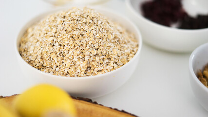 white bowl of porridge with granola ingredients around