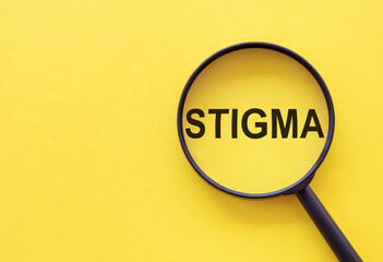 The word STIGMA is written on a magnifying glass on a yellow background.