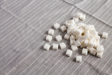 Organic White Sugar Cubes on cloth, low angle view. Copy space.