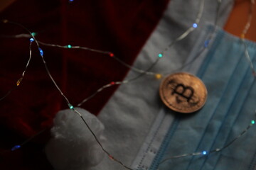 Santa hat and Bitcoin coin, colored candies on an orange background