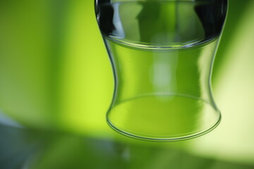 Kieliszek z wodą szklany zielone tło