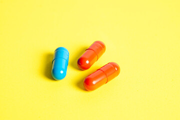 Heap of pills on yellow background