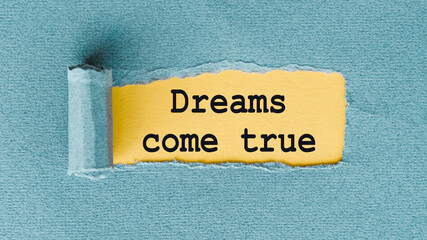 DREAMS COME TRUE text written under ripped and torn paper.