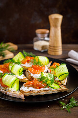 Toasts with salted salmon fish, ricotta cheese, fresh cucumber and ciabatta bread