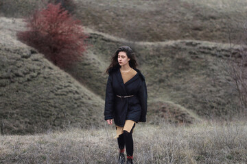 Beautiful calm brunette girl walks on the edge of the cliff. Beautiful nature.