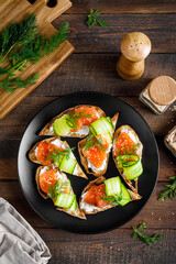 Toasts with salted salmon fish, ricotta cheese, fresh cucumber and ciabatta bread