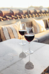 Two glasses of red wine on a restaurant luxury terrace, sunset light