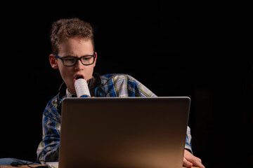 Boy with lint roller learning in front of laptop