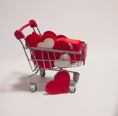 A small trolley that is filled with small hearts made of fabric