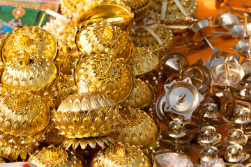 Fototapeta na wymiar Golden Colored Floral Shaped Decorative Metal Bowls and Other Designer Vessels For Pooja Puja