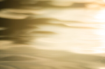 abstract blurry background if golden water surface at sunset