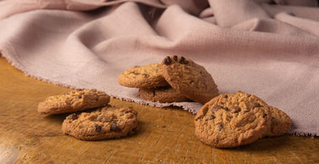 Cookies arranged on a rustic wooden surface with fabric, selective focus.