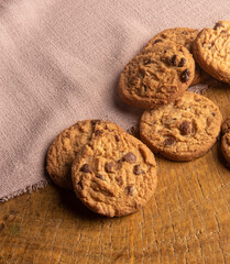 Cookies arranged on a rustic wooden surface with fabric, selective focus.