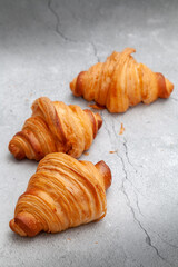 Fresh baked croissants on cement background.