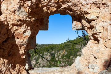 beautiful view with natural framing of the ruins of the Muslim fortification of the castle of Marinyén on the mountain in Benifairó de la Valldigna, Valencian Community, Spain