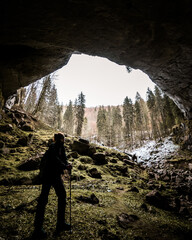 Hiker in the mountains 
Cave opening