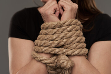 Woman with hands tied with rope