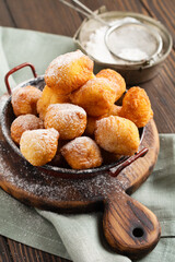 Little Donuts. Homemade curd fried cookies in deep fat and sprinkled with icing sugar in a vintage plate on a light background. Selective focus.