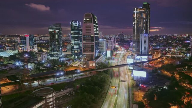 Hyperlapse, aerial view, of the Petaling Jaya district, Selangor, Malaysia, with skyscraper on Federal Highway freeway moving traffic at night