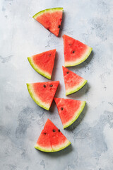 Slices of fresh watermelon with ice on a blue concrete background. Detox and vegetarian concept. Top view, copy space, banner