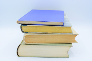 Isolated books, stacked over one another in front of a white background