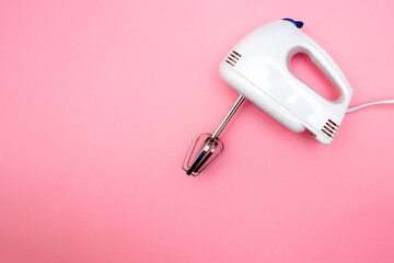 electric blender with stirring attachments on solid pink background