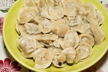 Cooked dumplings in a green plate on the dining table