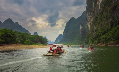 boats are rolling tourists on the river. The Li River (Lijiang) is located in Guilin, Guangxi province in southern China. - obrazy, fototapety, plakaty