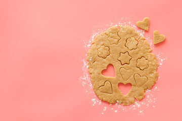 Cutting out heart-shaped cookies on dough top view