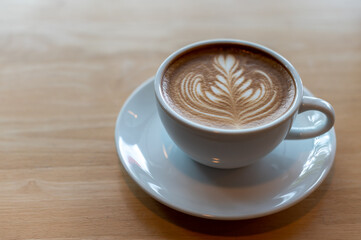 Latte art coffee cup on wooden table