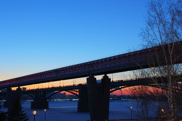 two bridges across the ob river in winter in Novosibirsk at sunset