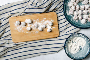 Round patties dipped in flour on a cutting board